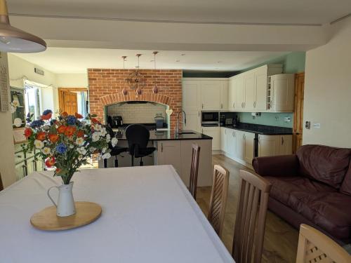 a kitchen with a table with a vase of flowers on it at Beautiful Victorian Farmhouse in Ottery Saint Mary