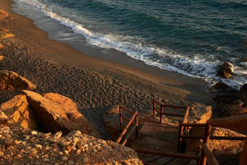 a stairway leading down to a beach with the ocean at PAROCKS Luxury Hotel & Spa in Ambelas