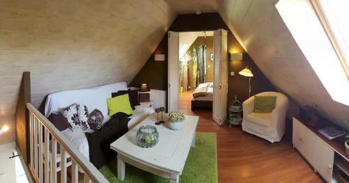 Cette chambre mansardée comprend un lit et une table. dans l'établissement Gite de charme entre mer et campagne, 4 étoiles, à Plestin-les-Grèves