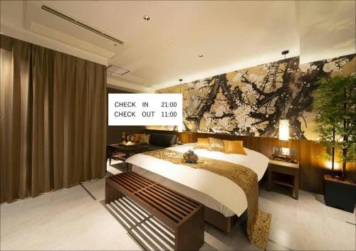 a bedroom with a bed and a painting on the wall at ホテル Tiger & Dragon 男塾ホテルグループ in Gifu