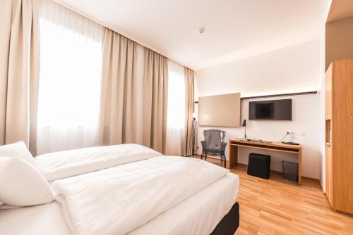 a hotel room with a bed and a desk at Göttfried - essen trinken schlafen in Linz