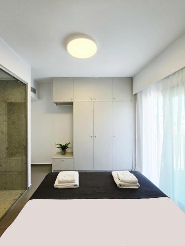 a bedroom with a large bed with two towels on it at Hermes&Dione in Argoulidhés