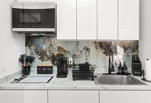 a kitchen with a sink and a microwave at Modern 3BR Stay - Up to 7 Guests - 20 Mins to NYC in West New York