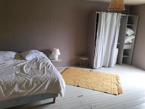 une chambre avec un lit et un tapis au sol dans l'établissement Studio in all its simplicity, à Le Bourdet
