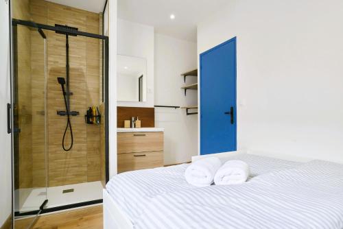 - une chambre avec une douche et un lit avec des serviettes dans l'établissement Maison du Vieux lille - moderne et authentique, à Lille
