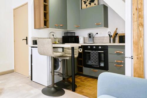 une cuisine avec des placards verts et un comptoir dans l'établissement Maison du Vieux lille - moderne et authentique, à Lille