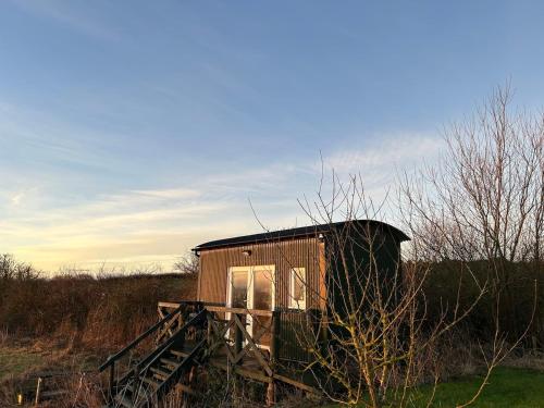 a small shack sitting in the middle of a field at Shepherds hut in 7 acre field in Ludworth