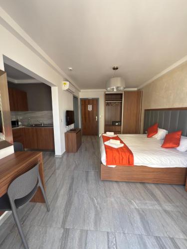 a bedroom with a bed and a desk and a kitchen at The Urban Suites in Il-Gżira