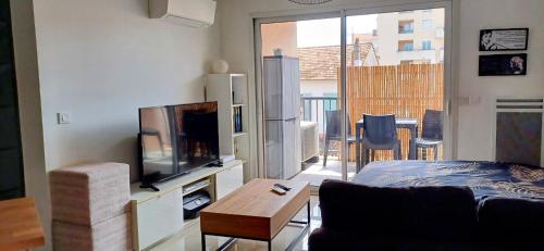 un salon avec un canapé et une télévision à écran plat dans l'établissement Appartement T2 CANNES LA BOCCA, à Cannes