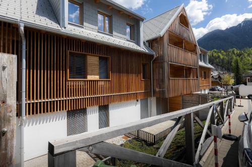 a house with a wooden fence next to it at Apartments Alpine Nest in Kranjska Gora