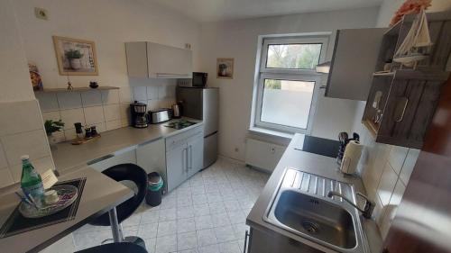 a small kitchen with a sink and a window at Modernes ,gemütliches Gäste Appartement in Zwickau in Zwickau