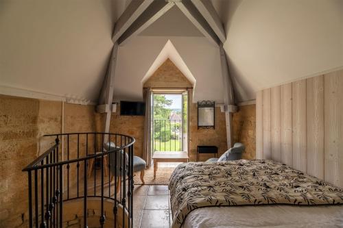 une chambre avec un lit et une fenêtre dans l'établissement Le Belvédère du Petit Manoir, à Vitrac