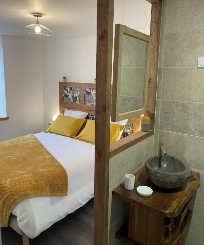 a bedroom with a large bed with a sink at Appartement avec vue et sauna - Centre Nérac in Nérac