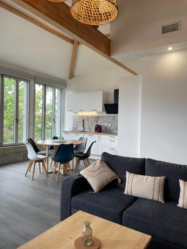 a living room with a blue couch and a table at Appartement avec vue et sauna - Centre Nérac in Nérac