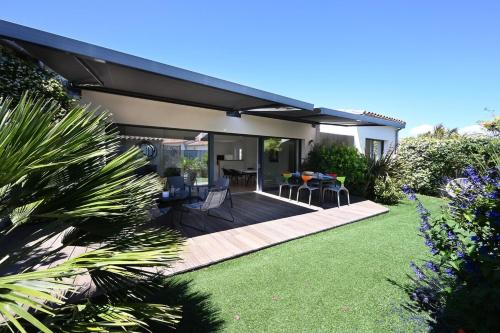 une arrière-cour avec une terrasse meublée d'une table et de chaises dans l'établissement 480 Serenity - Relaxation & Spa, à La Flotte