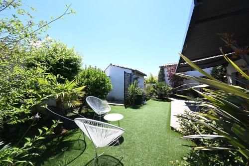 un petit jardin avec deux chaises et de l'herbe dans l'établissement 480 Serenity - Relaxation & Spa, à La Flotte