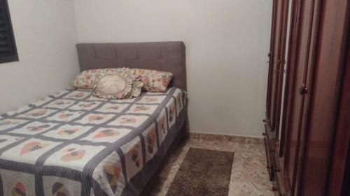 a bedroom with a bed with a comforter on it at Chácara Sérgio Água Bonita in Piracicaba