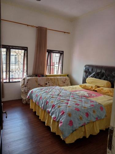 a bedroom with two beds and two windows at Villa gunung mas c6 in Berastagi