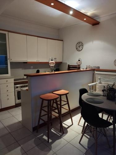 a kitchen with a counter and some chairs and a table at Mare Mia in Loutraki