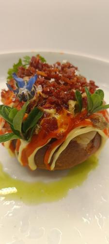 a sandwich with sauce and cheese on a white plate at Locanda la Rocca Residenza d'Epoca in Fossombrone