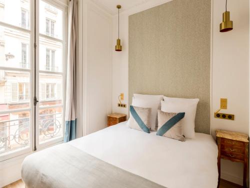 une chambre avec un lit blanc et une fenêtre dans l'établissement Merveil - Luxury Suite -ChampsElysees-Florentin II, à Paris