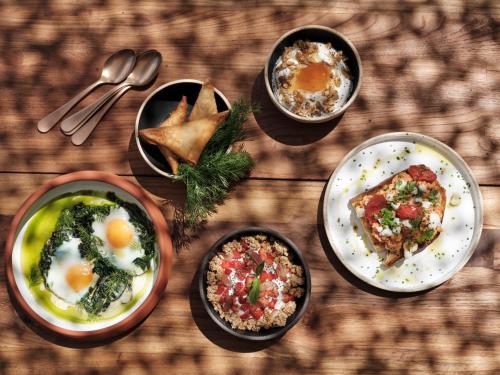 a table with plates of food on a wooden table at Stamna Sifnos a member of Design Hotels in Sifnos