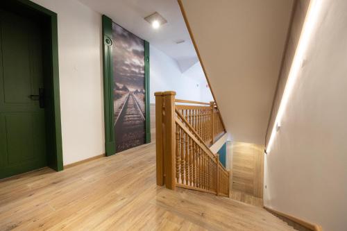 a hallway with a wooden staircase with a green door at Vila Savica Bled in Bled