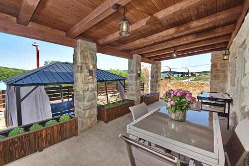 a patio with a table and a gazebo at בקתה בשמורה in Shomera