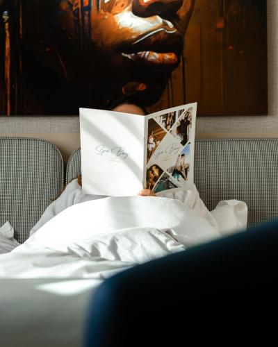 a person laying in bed reading a book at Elite View Hotel Dakhla in Dakhla