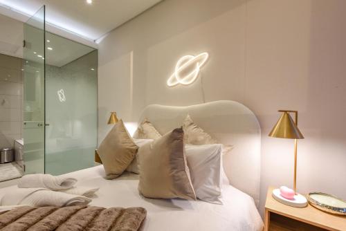 a bedroom with a white bed and a glass shower at Park Central Residence - Building with Generator in Johannesburg