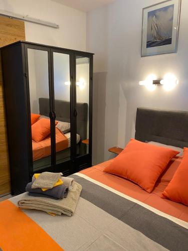 - une chambre avec un lit orange et un miroir dans l'établissement T2 Poulen, climatise vue mer , parking inclus NON FUMEUR, à La Ciotat