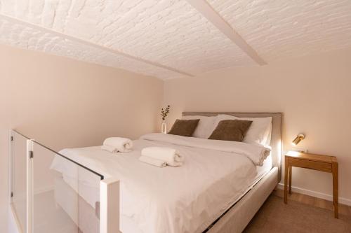 布达佩斯Szerb Boutique Suites, by BQA的卧室里有一张白色的床，床上有两条毛巾