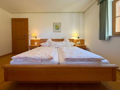 a bedroom with a large bed with two pillows at Ferienwohnungen Zweckl in Marktschellenberg