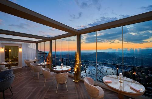 a restaurant with tables and chairs and a view at Nuvole Garden Hotel in Brunate