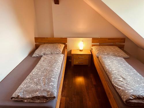two beds in a small room with a lamp on a table at Moderne Wohnung im Grünen in WRN in Werneuchen