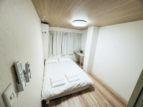 a small room with a bed and a window at Mori Hotel in Osaka