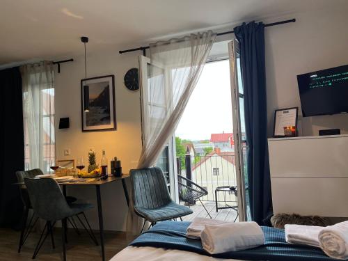 a bedroom with a bed and a table and a window at BEYOND Staying Apartments Passau in Passau