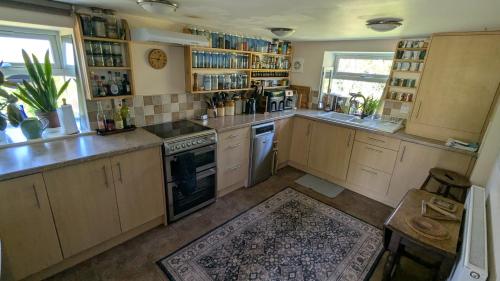 a kitchen with wooden cabinets and a stove top oven at Rose Cottage in Ledbury