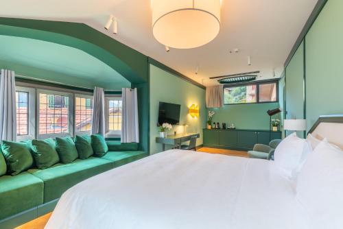 a bedroom with a large bed and a couch at Casa Du Lac, by R Collection Hotels in Varenna