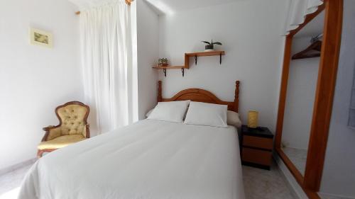 una camera da letto con un letto bianco e una sedia di Uviya 2 a Famara