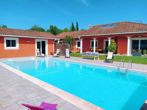 une piscine devant une maison dans l'établissement Villa la Palmeraie, à Saint-Martin-de-Seignanx
