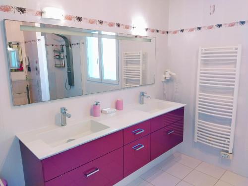 une salle de bain avec un lavabo et un miroir dans l'établissement Villa la Palmeraie, à Saint-Martin-de-Seignanx