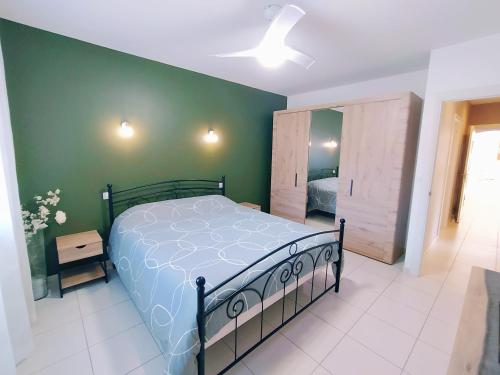 une chambre avec un lit et un mur végétal dans l'établissement Villa la Palmeraie, à Saint-Martin-de-Seignanx