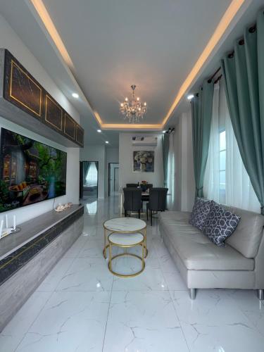 a living room with a couch and a table at บ้านพักขอนแก่น บ้านมั่งมี ใจกลางเมือง in Ban Chek