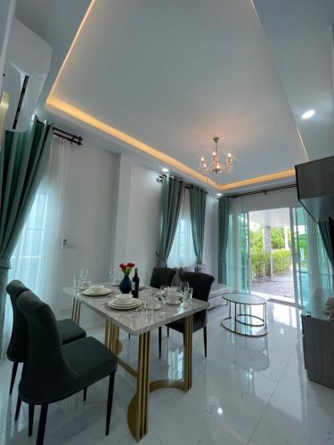 a dining room with a table and chairs at บ้านพักขอนแก่น บ้านมั่งมี ใจกลางเมือง in Ban Chek