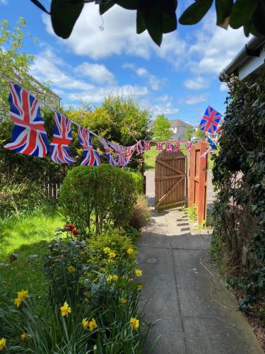 a garden with british flags hanging over a gate at Caledonia House in Rosyth