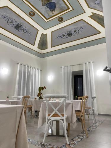 a dining room with tables and chairs and a coffered ceiling at Palazzo dei Baroni in San Bartolomeo in Galdo