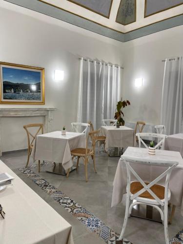 a dining room with white tables and chairs at Palazzo dei Baroni in San Bartolomeo in Galdo