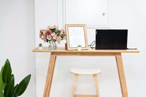 a desk with a laptop and flowers on it at Hotel Casa Jazmin in Granada