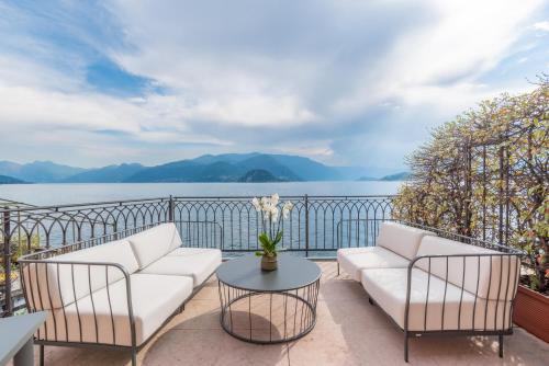 a balcony with two white couches and a table at Casa Du Lac, by R Collection Hotels in Varenna